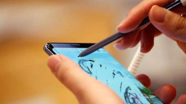 একজন সম্ভাব্য ক্রেতা দোকানে স্যামসাং গ্যালাক্সি ফোন যাচাই করছেন।