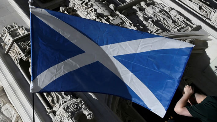যুক্তরাজ্যের সুপ্রীম কোর্টের বাইরে স্কটল্যান্ডের পতাকা ঝুলিয়ে স্বাধীনতাকামী পক্ষ বিক্ষোভ করছে। ছবি: রয়টার্স