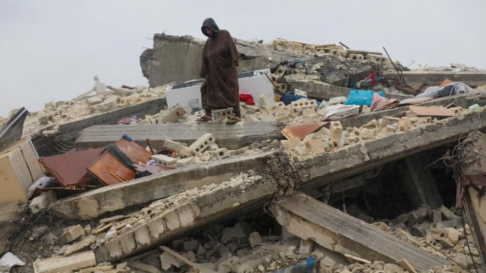 সিরিয়ার জানদারিস শহরে ধ্বংসস্তুপের ওপর এক ব্যক্তি দাঁড়িয়ে আছেন। ছবি: রয়টার্স