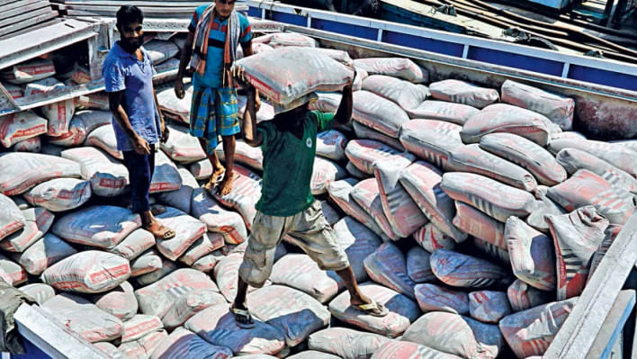 সিমেন্টের বস্তা বহন করছেন শ্রমিকরা। ফাইল ছবি: স্টার