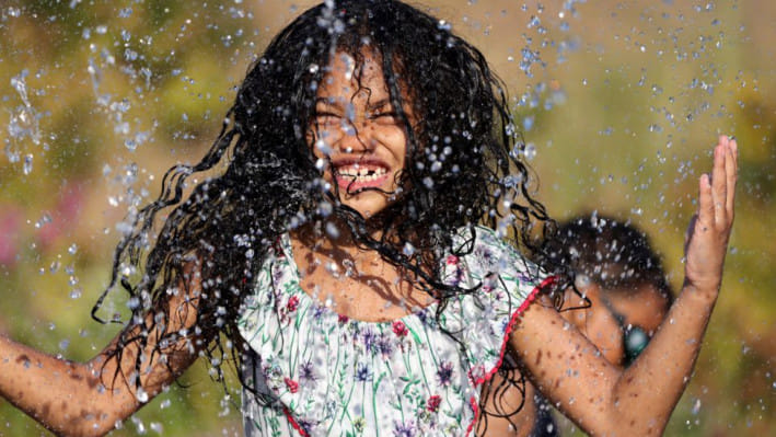 ৭ বছর বয়সী মার্কিন শিশু আইসিস তাপদাহের হাত থেকে বাঁচতে পানি নিয়ে খেলছে। ফাইল ছবি: রয়টার্স