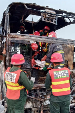 পাকিস্তানে দুর্ঘটনা কবলিত বাস থেকে এক নিহত যাত্রীর মরদেহ বের করছেন উদ্ধারকর্মীরা। ছবি: এএফপি