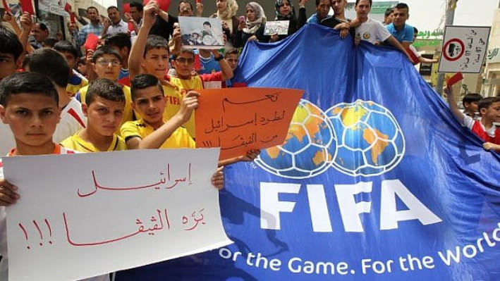 ইসরায়েলকে ফিফা থেকে নিষিদ্ধ করার দাবিতে পশ্চিম তীরে লাল কার্ড ও ব্যানার নিয়ে বিক্ষোভ করছেন ফিলিস্তিনিরা। ফাইল ছবি: এএফপি (২০১৫)