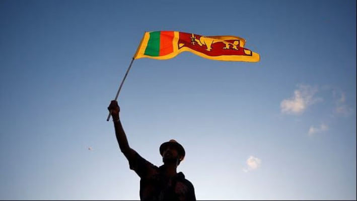 শ্রীলঙ্কার পতাকা উড়িয়ে প্রেসিডেন্ট গোতাবায়া রাজাপাকসের বিরুদ্ধে বিক্ষোভ করছেন দেশটির এক নাগরিক। ফাইল ছবি: রয়টার্স (১৬ এপ্রিল, ২০২২) 