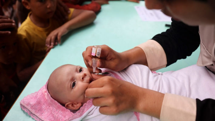 এক ফিলিস্তিনি শিশুকে টিকা দিচ্ছেন স্বাস্থ্যকর্মী। ছবি: এএফপি
