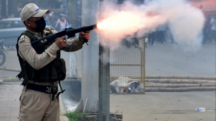 মণিপুরে শিক্ষার্থীদের ছত্রভঙ্গ করতে টিয়ার গ্যাস শেল ছুঁড়ছেন পুলিশ কর্মকর্তা। ছবি: রয়টার্স