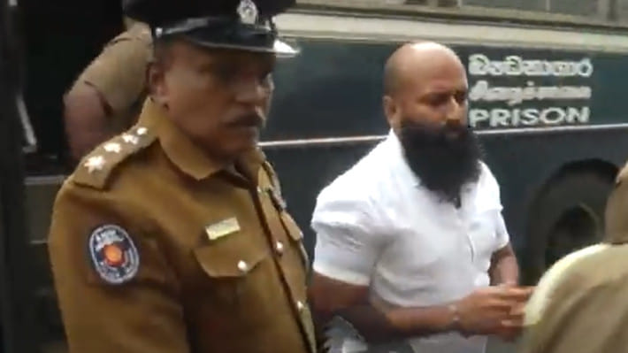 কড়া প্রহরায় গানেমুল্লে সঞ্জিবাকে আদালতে হাজির করা হয়। ছবি: ভিডিও থেকে  