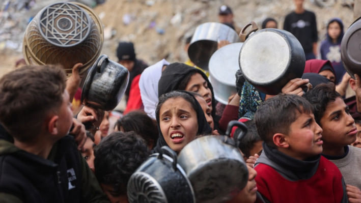 গাজার বেইত লাহিয়া এলাকায় একটি দাতব্য লঙ্গরখানা থেকে ইফতারের জন্য খাবার সংগ্রহ করতে ফিলিস্তিনি শিশুরা অপেক্ষা করছে। ছবি: এএফপি