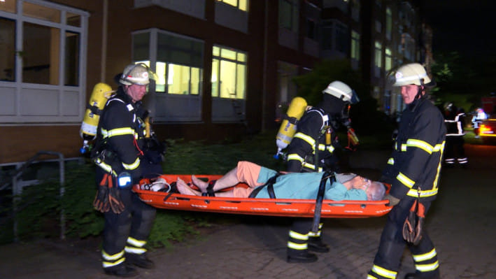 হামবুর্গের মারিয়েনক্র্যানকেনহস হাসপাতালে অগ্নিকাণ্ডে আহত এক ব্যক্তিকে উদ্ধার করে নিয়ে এসেছেন দমকল বাহিনীর কর্মকর্তারা। ছবি: এএফপি