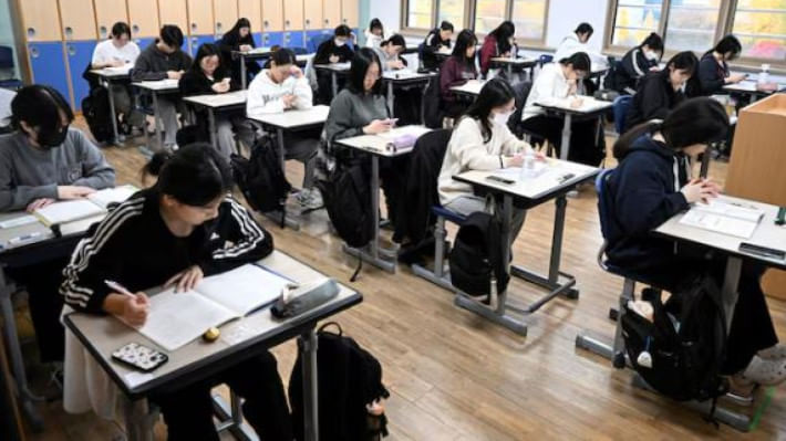 দক্ষিণ কোরিয়ার শিক্ষার্থীরা পরীক্ষা দেওয়ার জন্য শ্রেণিকক্ষে অপেক্ষা করছেন। সবার ডেস্কেই মোবাইল দেখা যাচ্ছে। ফাইল ছবি: রয়টার্স