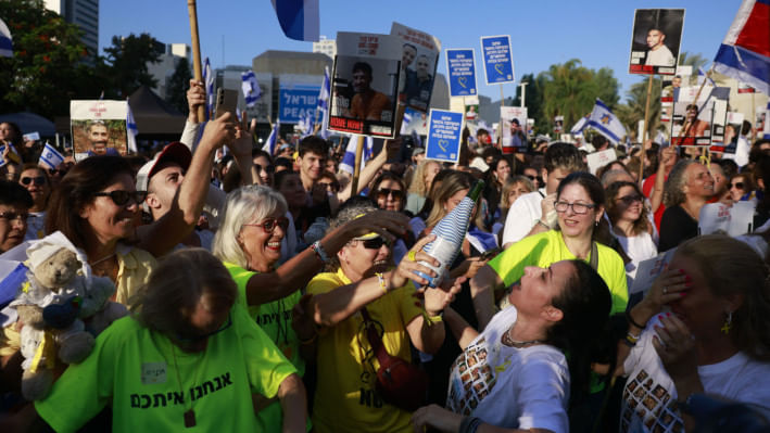 গাজায় ৭ জিম্মি মুক্তির খবরে তেল আবিবের হোস্টেজ স্কোয়ারে উল্লাসে ফেটে পড়েন ইসরায়েলিরা। ছবি: এএফপি