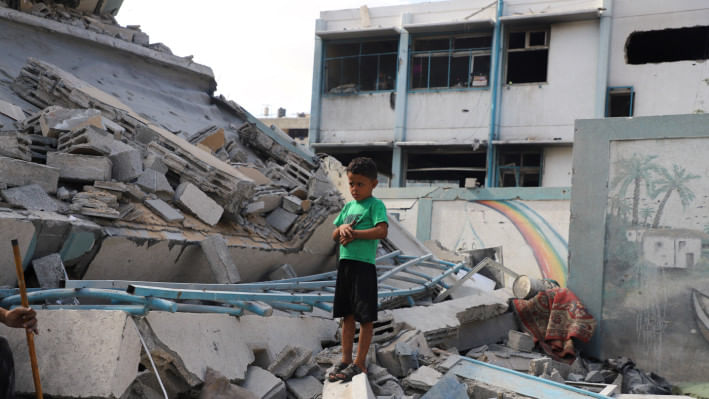 গাজার জেইতুন মহল্লার একটি স্কুল ইসরায়েলি হামলায় ধ্বংসের পর ধ্বংস্তুপের মাঝে দাঁড়িয়ে থাকে এক ফিলিস্তিনি শিশু । ফাইল ছবি: রয়টার্স