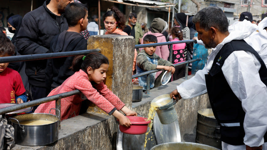 দক্ষিণ গাজার রাফাহ শহরে বাস্তুচ্যুত ফিলিস্তিনি শিশুরা একটি দাতব্য লঙ্গরখানা থেকে খাবার সংগ্রহ করছে। ফাইল ছবি: রয়টার্স