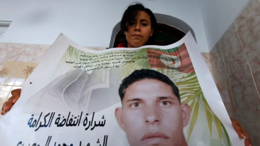 ভাইয়ের পোস্টার হাতে বিক্ষোভে অংশ নেন সামিয়া বোয়াজিজি। ফাইল ছবি: রয়টার্স
