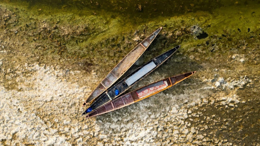 ইরাকের দক্ষিণাঞ্চলের বসরা প্রদেশের শুষ্ক জলাধারে পরিত্যক্ত অবস্থায় কাঠের নৌকা পড়ে আছে। ছবি: এএফপি