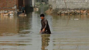 পাকিস্তানের নওশেরা জেলার একটি এলাকায় বন্যার পানির মধ্য দিয়ে হেঁটে যাচ্ছে এক বালক। ছবি: রয়টার্স (সেপ্টেম্বর ৩, ২০২২) 