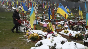 ইউক্রেন যুদ্ধে নিহত যোদ্ধাদের কবরে ফুল দিচ্ছেন এক নারী। ছবি: এএফপি