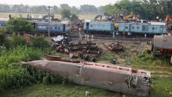 ভারী যন্ত্রপাতি ব্যবহার করে ঘটনাস্থল থেকে ক্ষতিগ্রস্ত ট্রেনের কোচগুলো সরানো হচ্ছে। ছবি: রয়টার্স