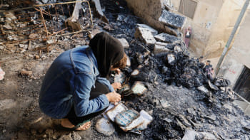 পশ্চিম তীরের জেনিন শরণার্থীশিবিরে ইসরায়েলি হামলার পর পুড়ে যাওয়া জিনিসের মাঝে সহায়সম্বল খুঁজে ফিরছেন এক ফিলিস্তিনি। ছবি: রয়টার্স