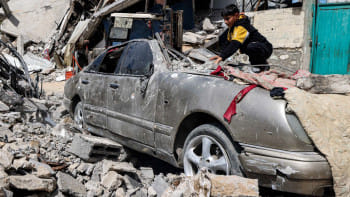 রাফায় ইসরায়েলি হামলায় ধ্বংস হয়ে যাওয়া একটি গাড়ির ওপর থেকে পাথর সরাচ্ছে এক শিশু। ছবি: রয়টার্স