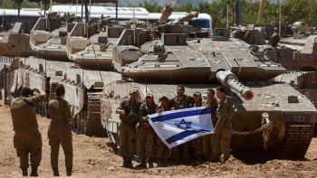 গাজা সীমান্তে ট্যাংকের সামনে দাঁড়িয়ে ছবি তুলছেন ইসরায়েলি সেনারা। ছবি: রয়টার্স