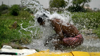 যমুনার তীরে পাইপ থেকে বের হয়ে আসা পানিতে গোসল করে গরমের হাত থেকে বাঁচার চেষ্টা করছেন এই দিল্লিবাসী। ছবি: এএফপি