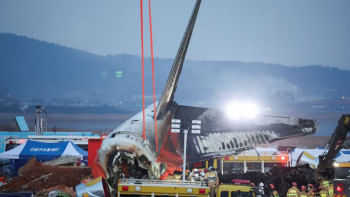 ক্রেন দিয়ে উড়োজাহাজ থেকে ধ্বংস্তুপ পরিষ্কারের চেষ্টা চালানো হচ্ছে। ছবি: রয়টার্স