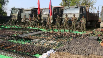 মিয়ানমারের সামরিক জান্তার কাছ থেকে ছিনিয়ে নেওয়া অস্ত্র, গোলাবারুদ, সামরিক ট্রাক ও অন্যান্য উপকরণসহ ছবি তুলছেন আরাকান আর্মির সদস্যরা। ফাইল ছবি: এএফপি